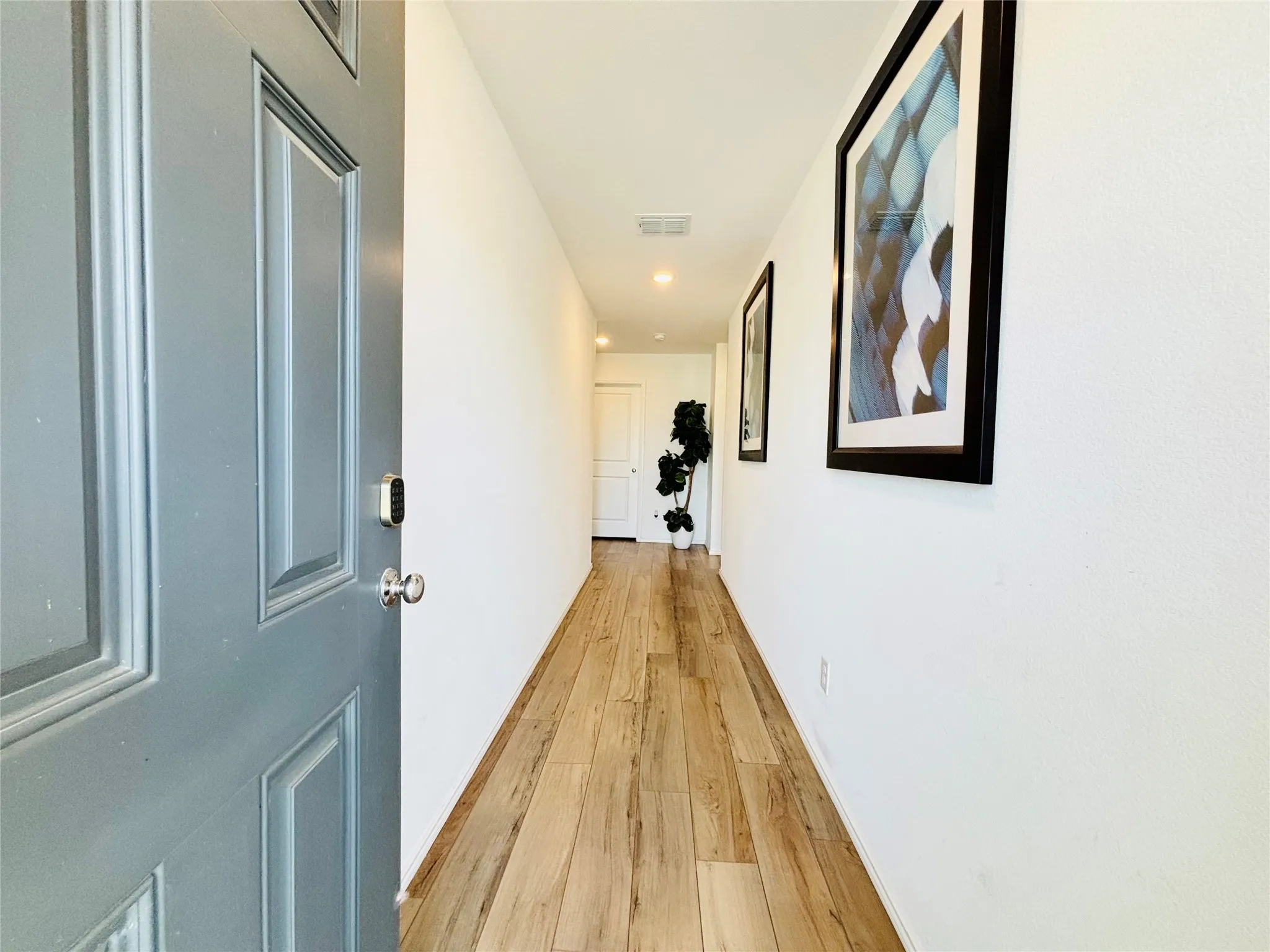 Hall with light wood-style flooring and recessed lighting