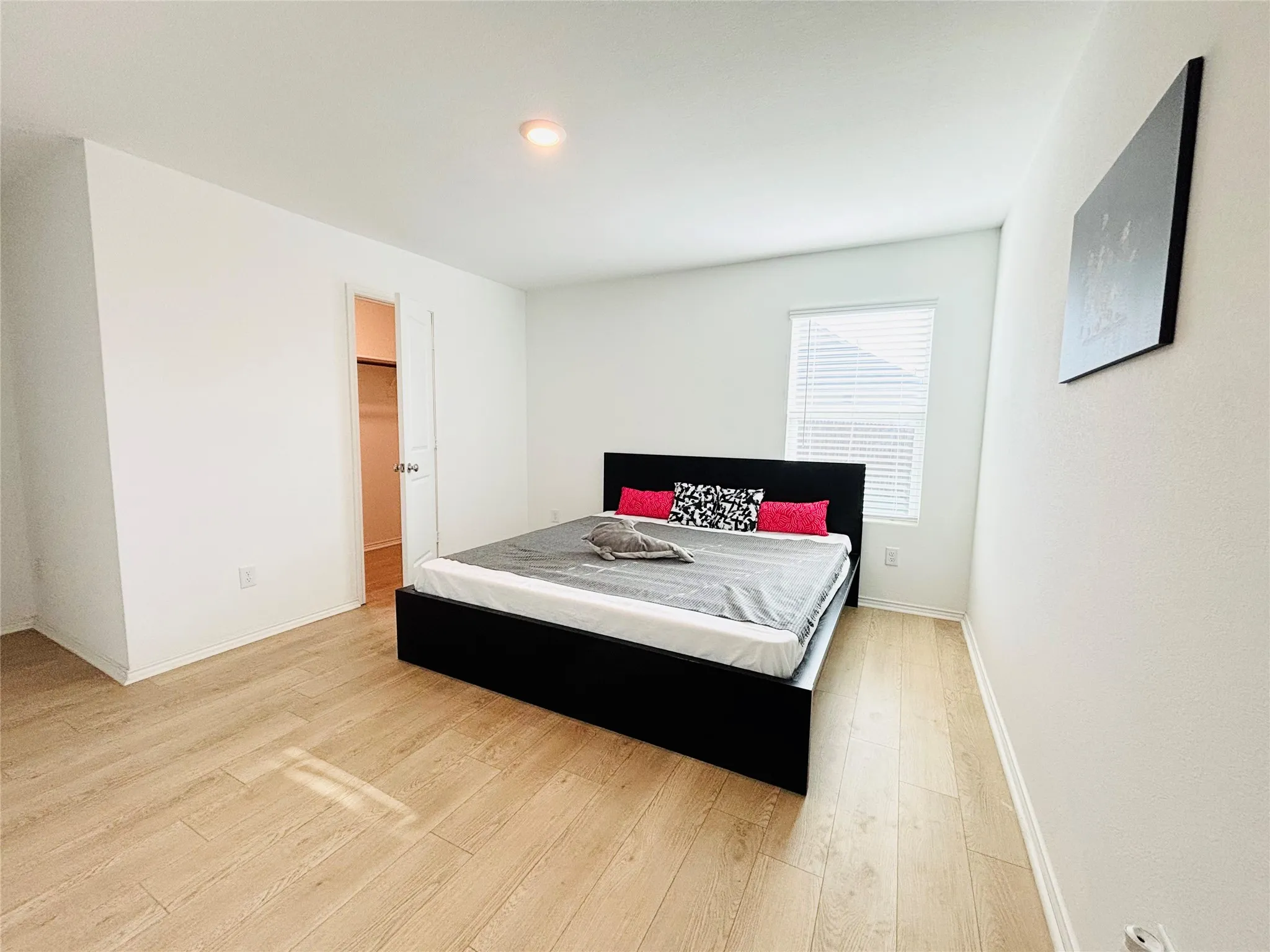 Bedroom with light wood-style floors and a spacious closet