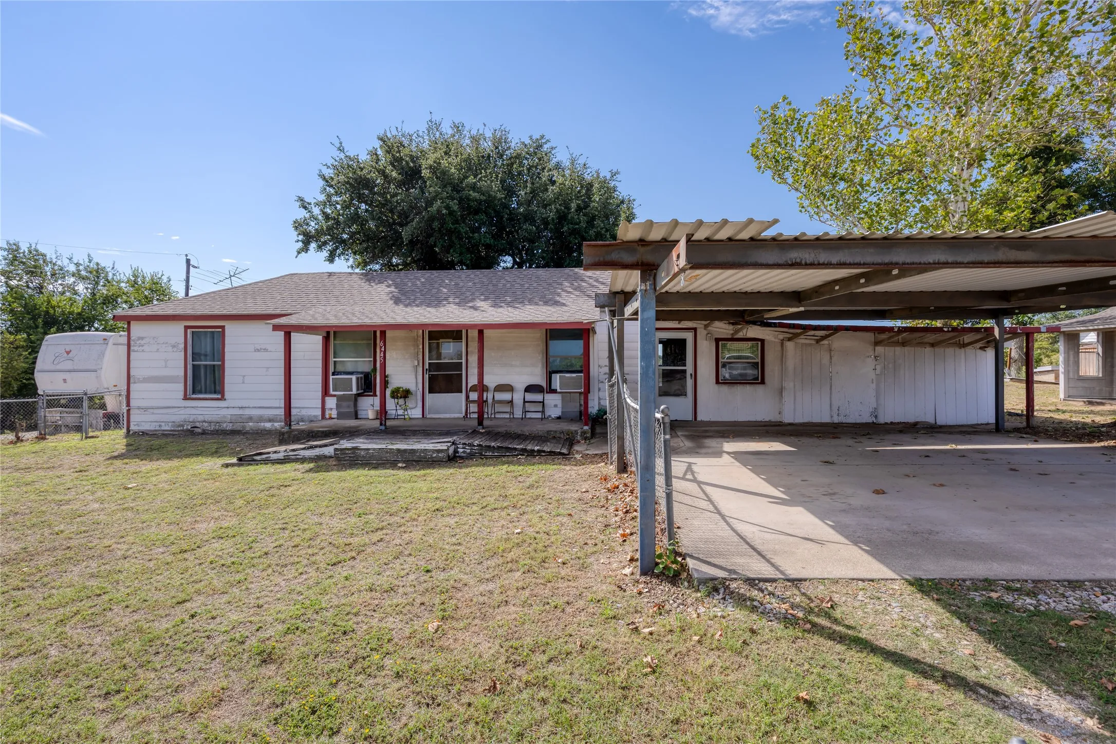 Ranch-style house featuring a carport, roof with shingles, and a patio