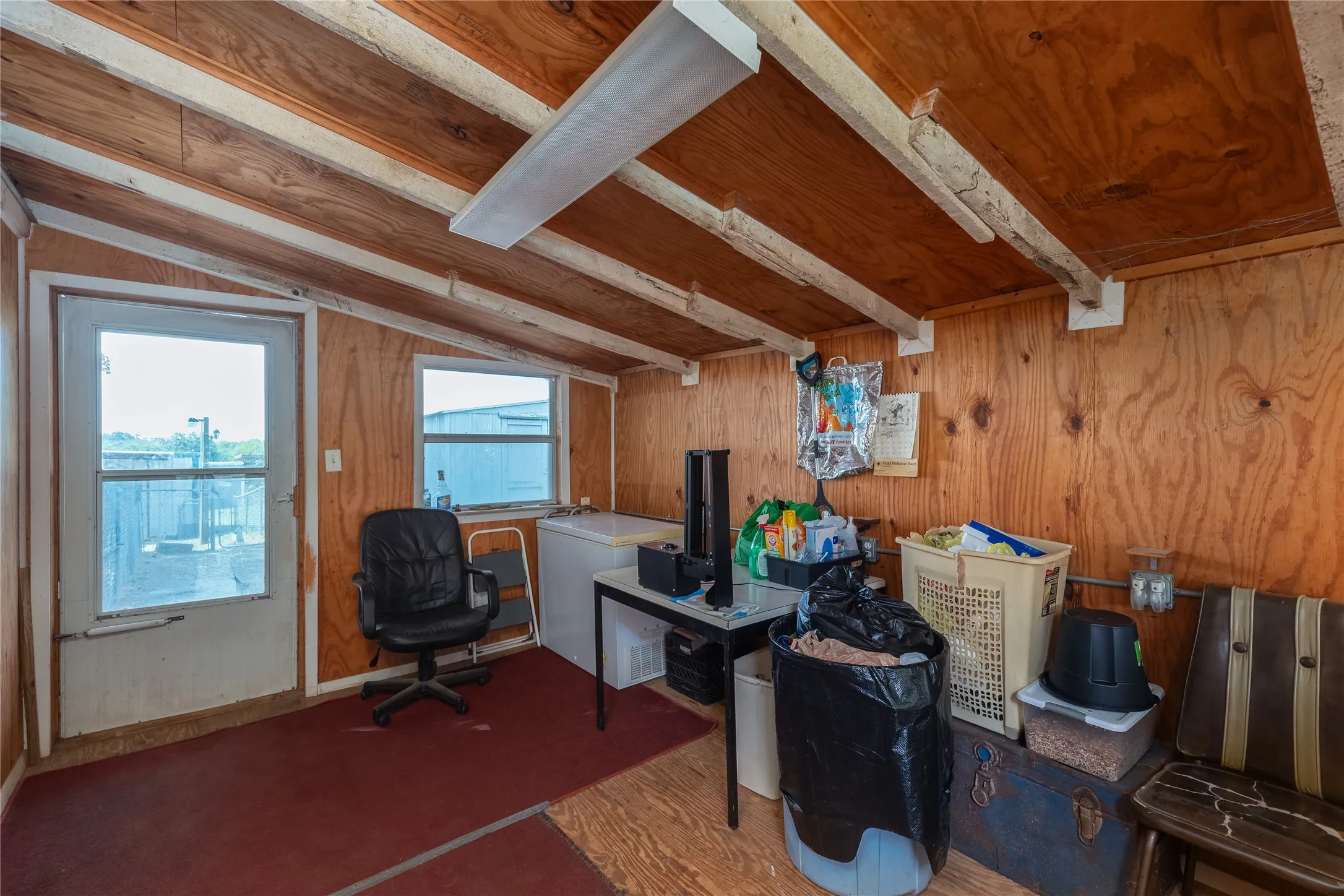 Home office featuring wood walls, wood finished floors, and a wooden ceiling with exposed beams