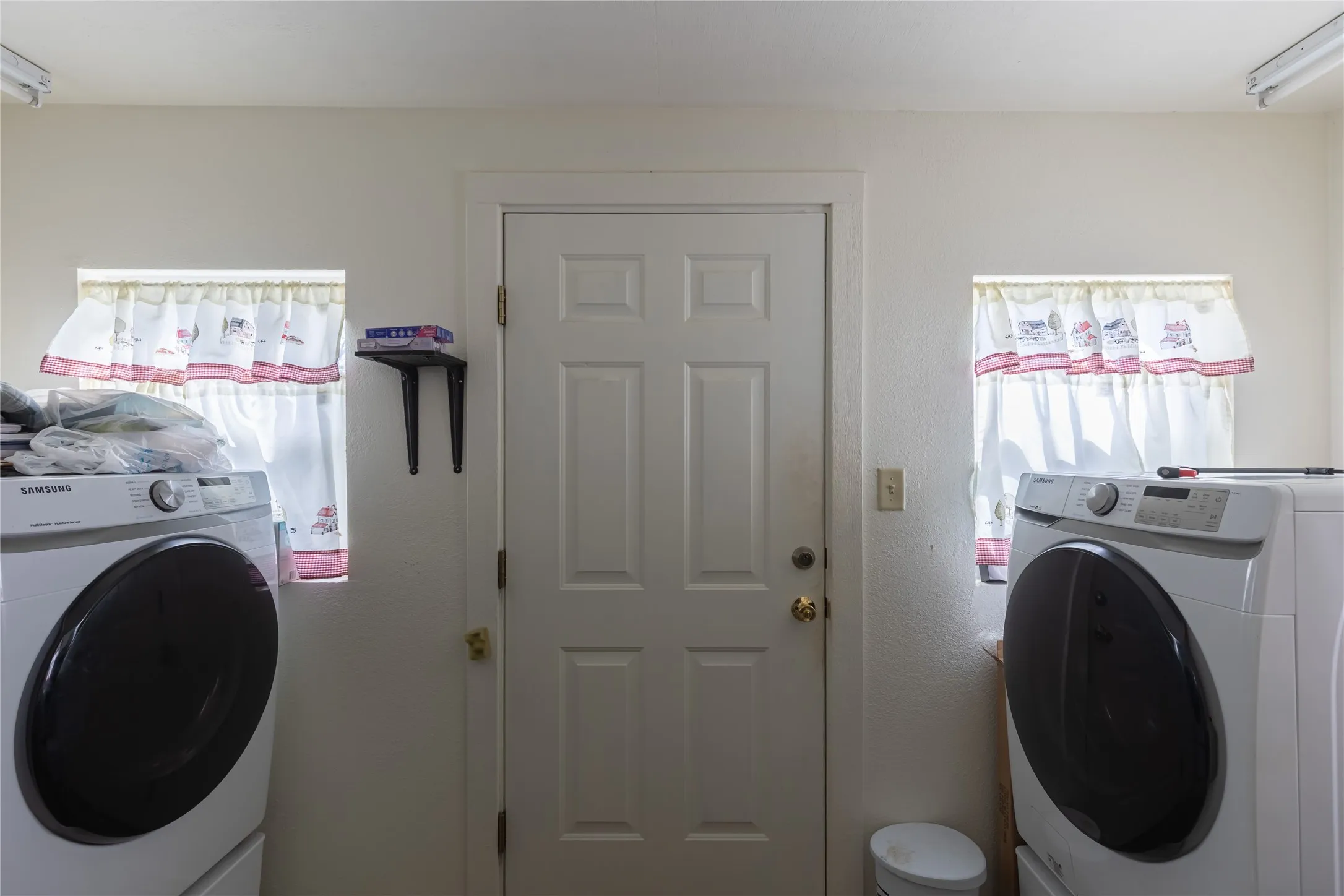 Laundry room with washer / dryer and track lighting