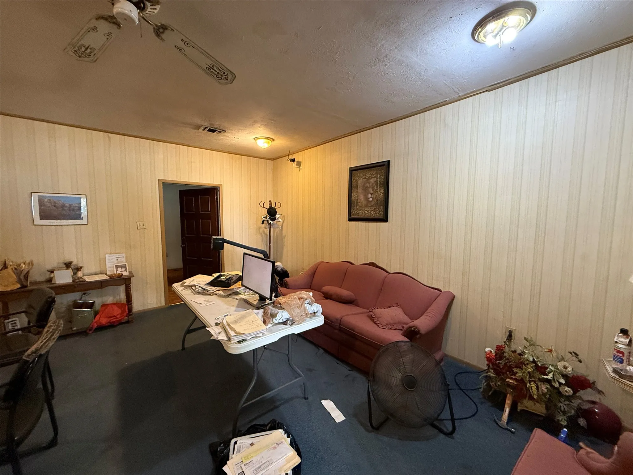 Living room with carpet, a textured ceiling, crown molding, and an office area