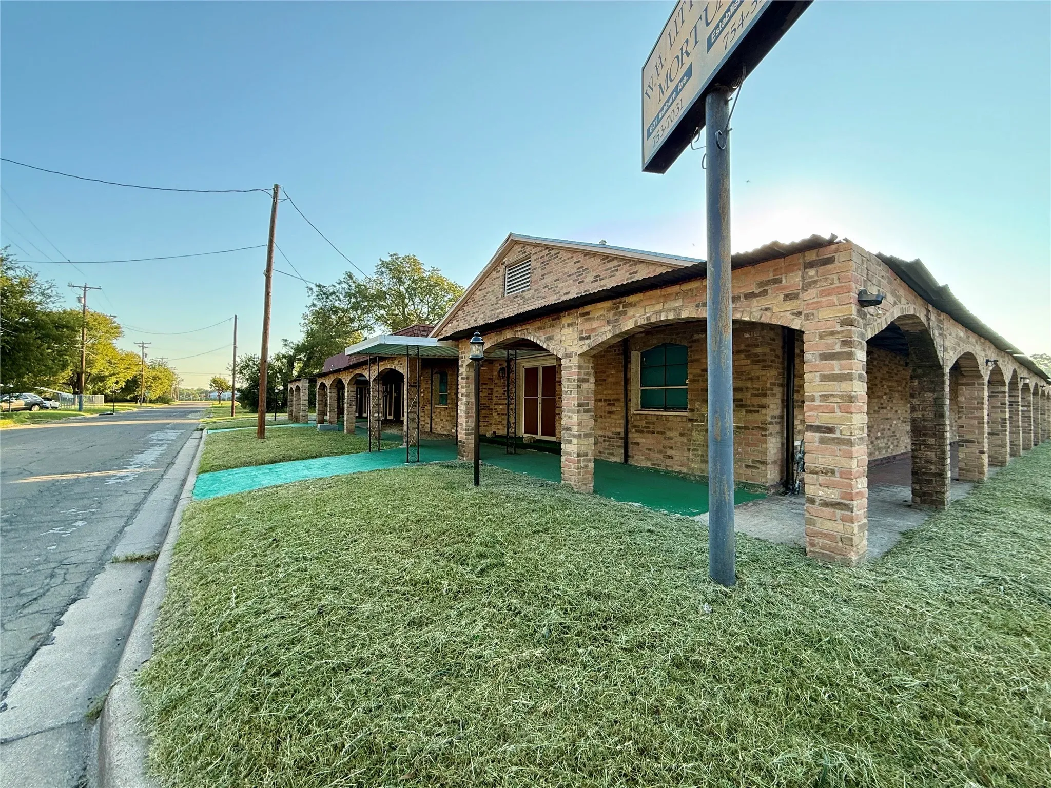 View of home's exterior with a lawn, brick siding, and a patio