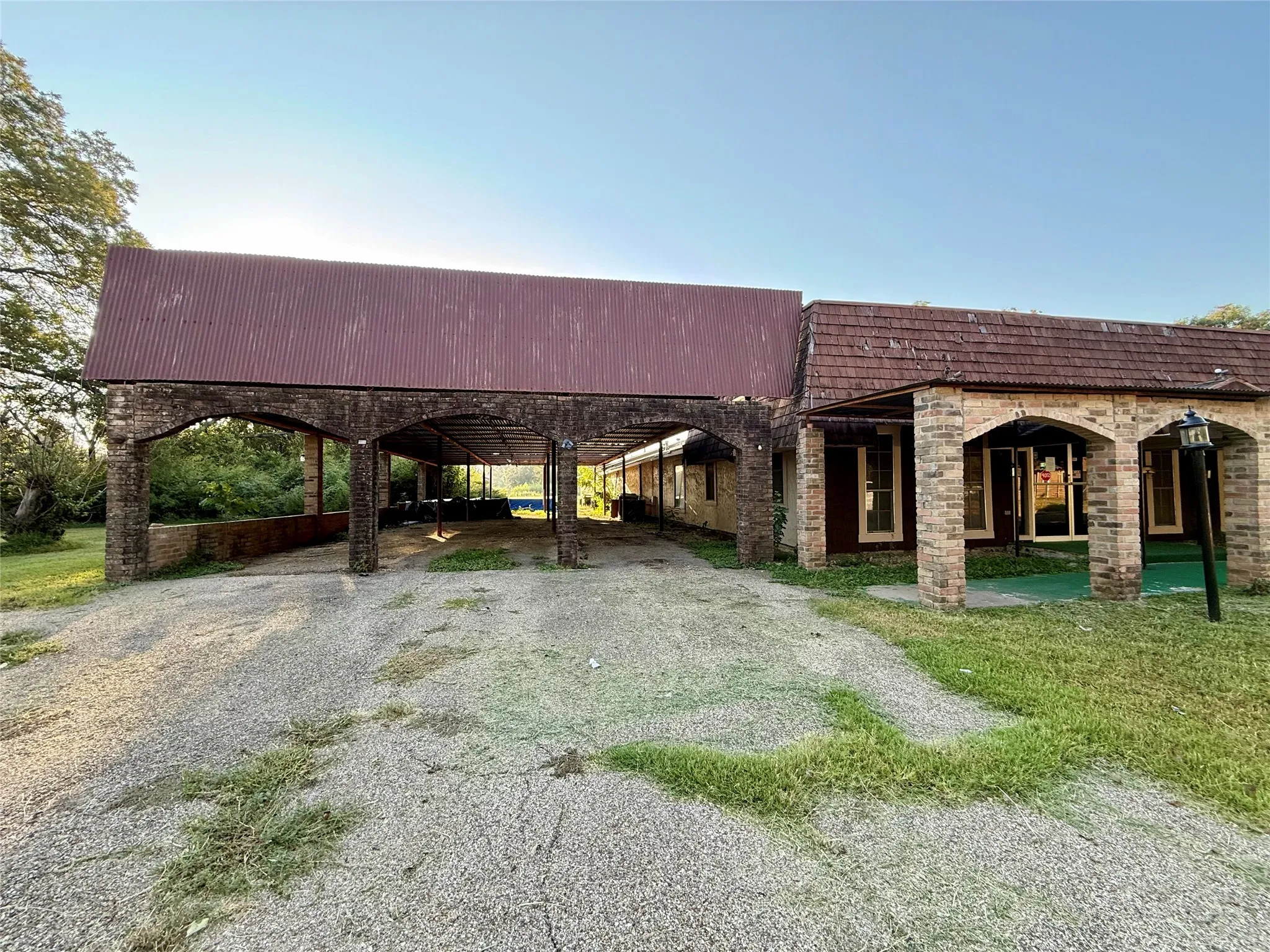 View of front facade with a patio area, driveway, and a front lawn