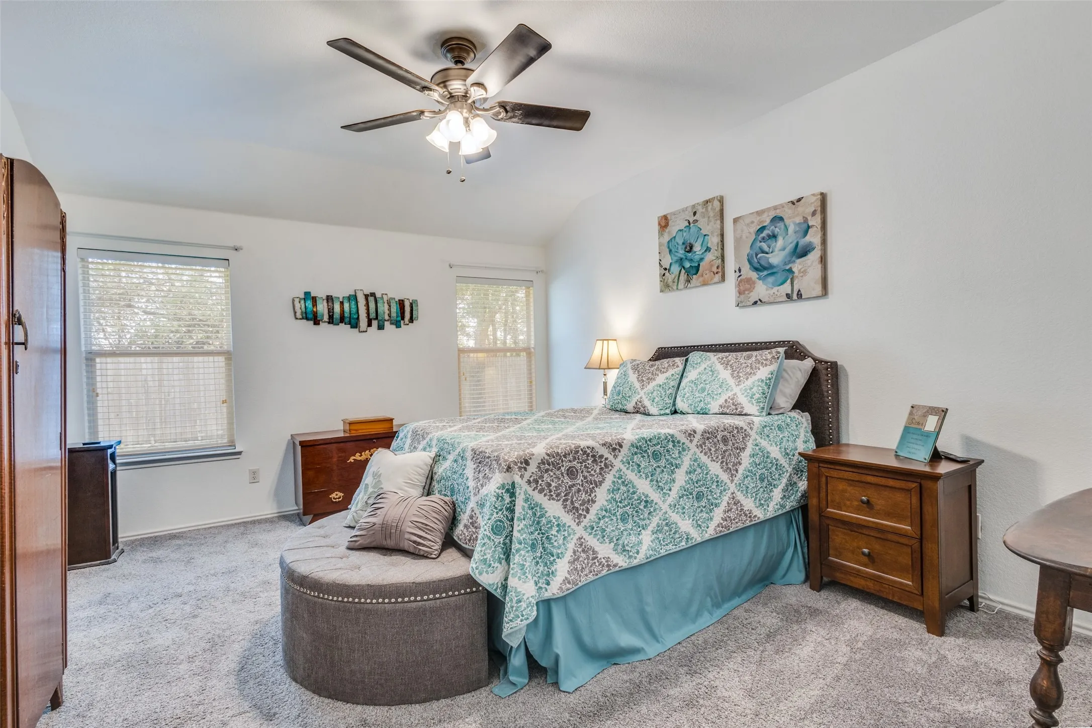 Carpeted bedroom with vaulted ceiling and ceiling fan