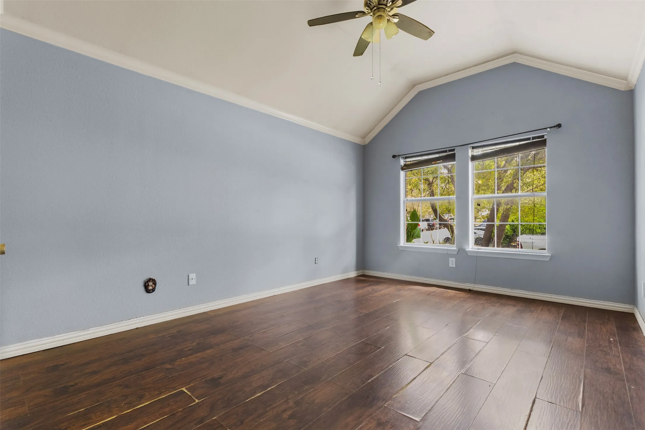 Unfurnished room with lofted ceiling, crown molding, a ceiling fan, and wood finished floors