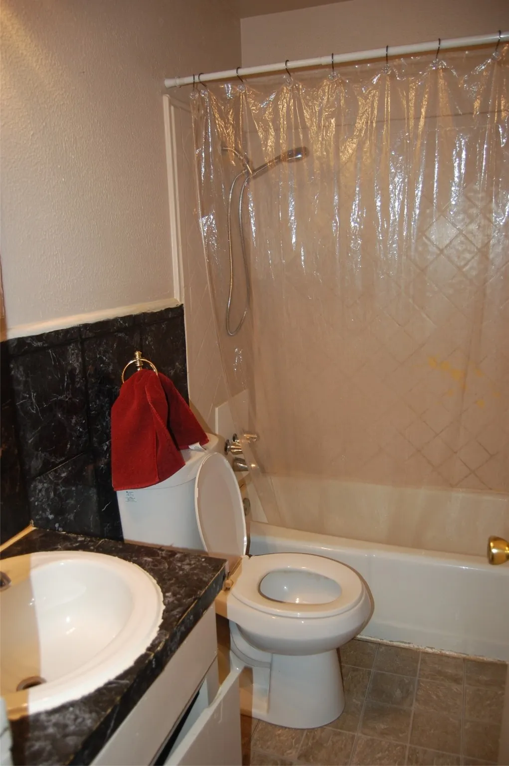 Bathroom with Tub / bath combo, vanity, a textured wall, and tile patterned floors