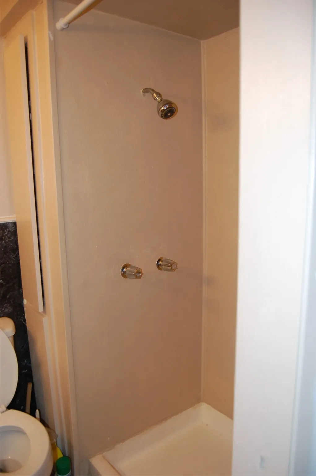 Full bath featuring a shower stall and toilet