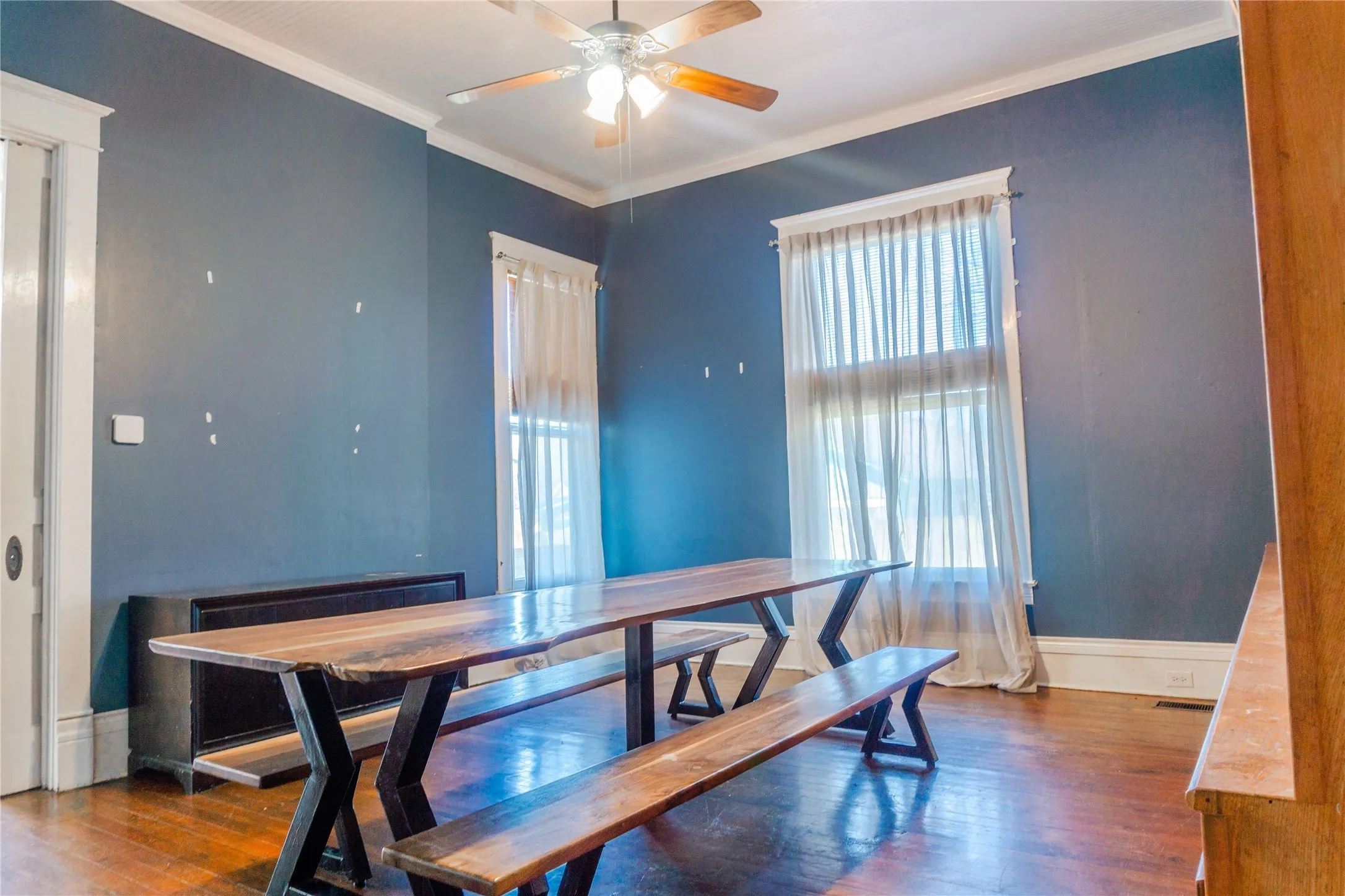 Dining space featuring crown molding, dark wood-style floors, and a ceiling fan