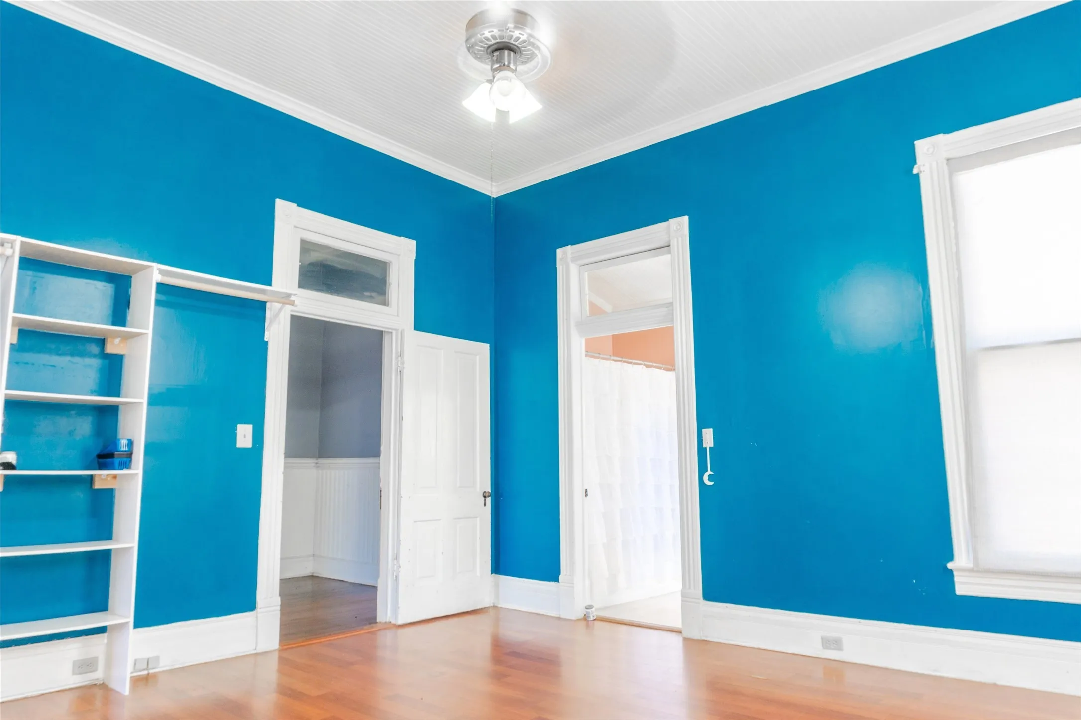 Unfurnished bedroom featuring ornamental molding, wood finished floors, ceiling fan, and a closet