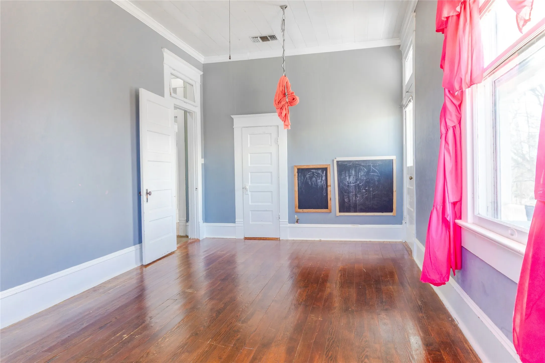 Unfurnished living room with hardwood / wood-style floors and crown molding
