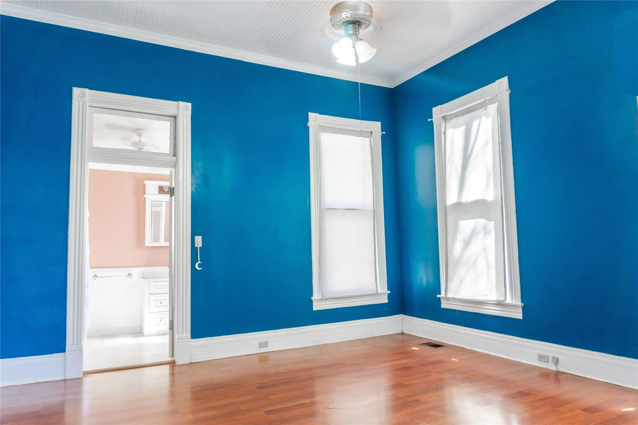 Empty room featuring wood finished floors and crown molding
