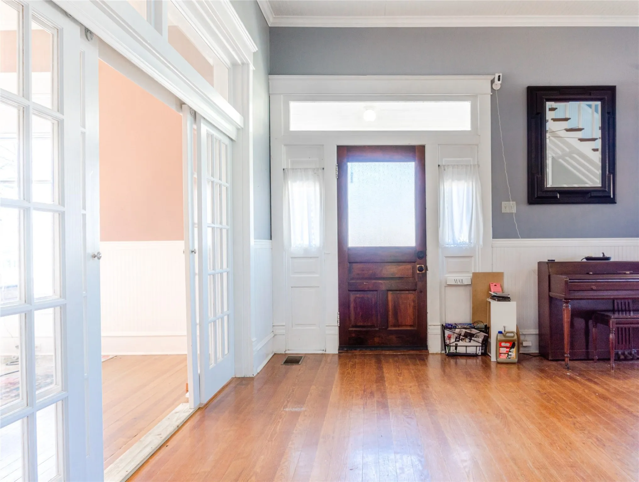 Entrance foyer with light wood-type flooring, wainscoting, and crown molding