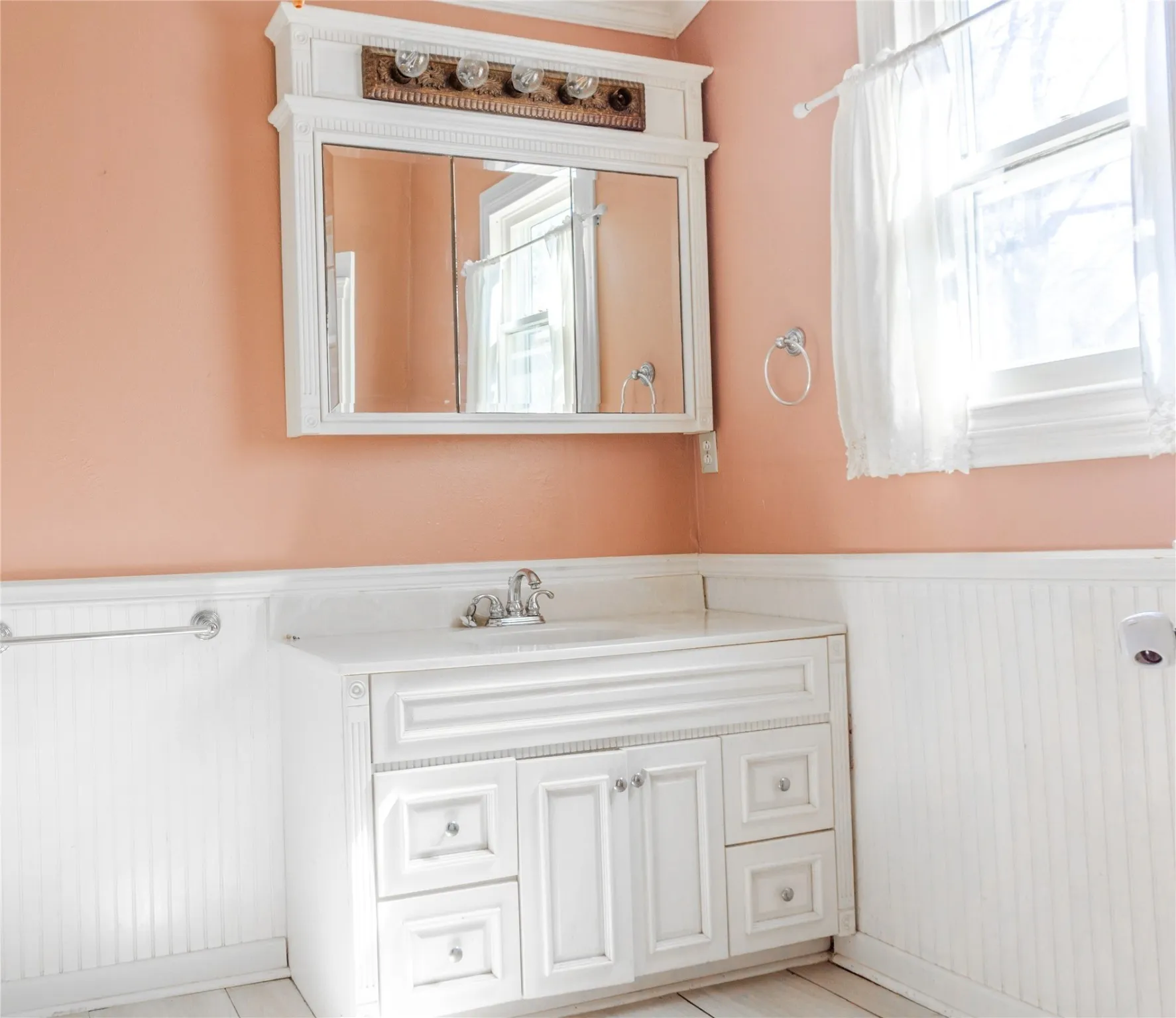 Bathroom featuring wainscoting, vanity, and wooden walls