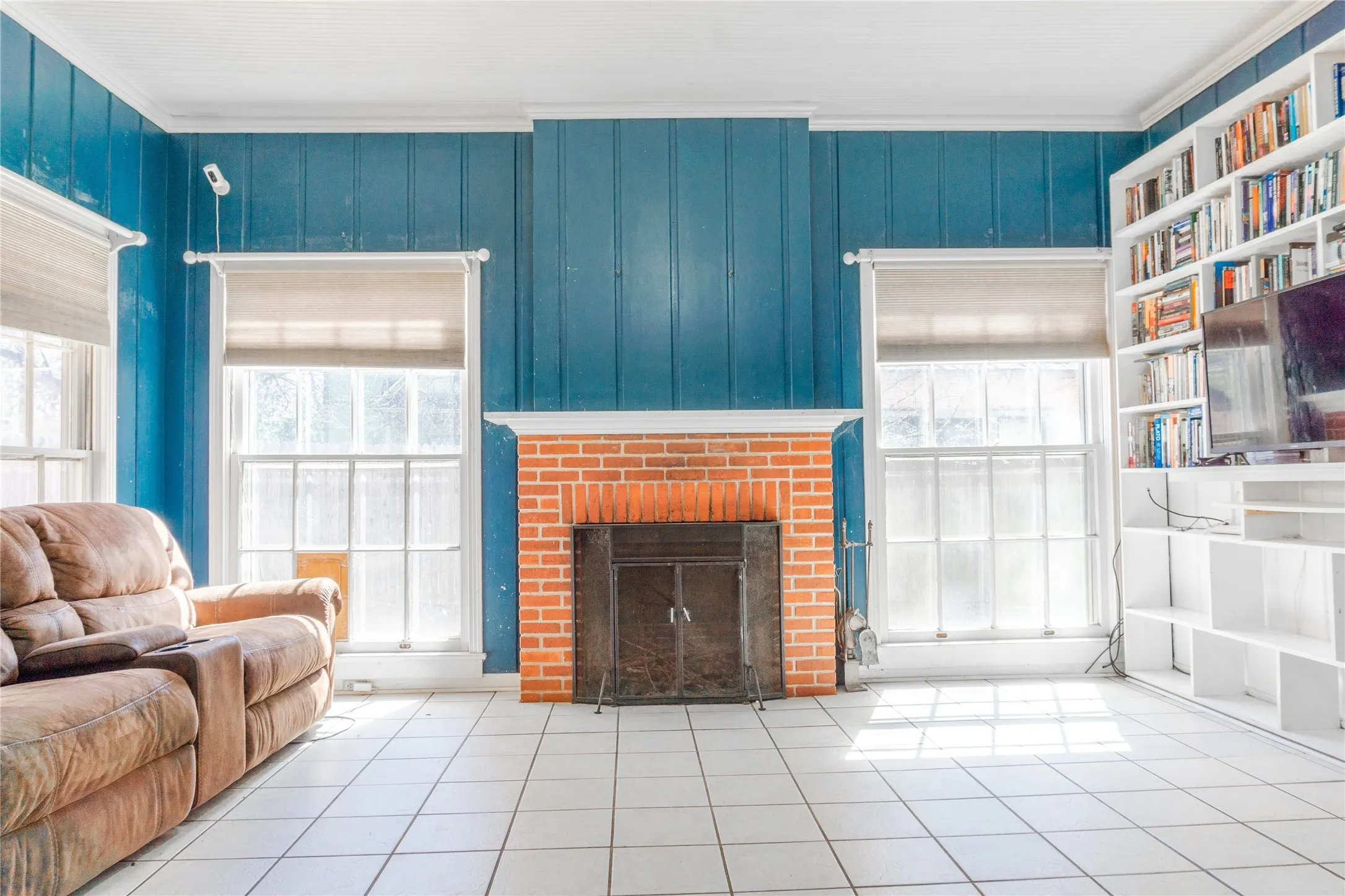 Tiled living area with a fireplace and ornamental molding