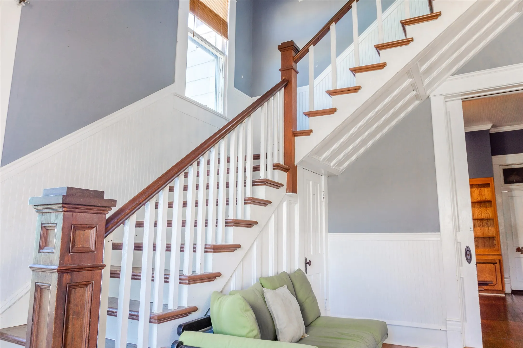 Stairs with wainscoting and a high ceiling