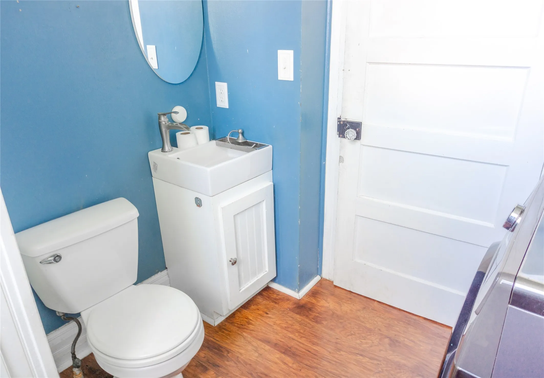 Half bathroom with wood finished floors and vanity