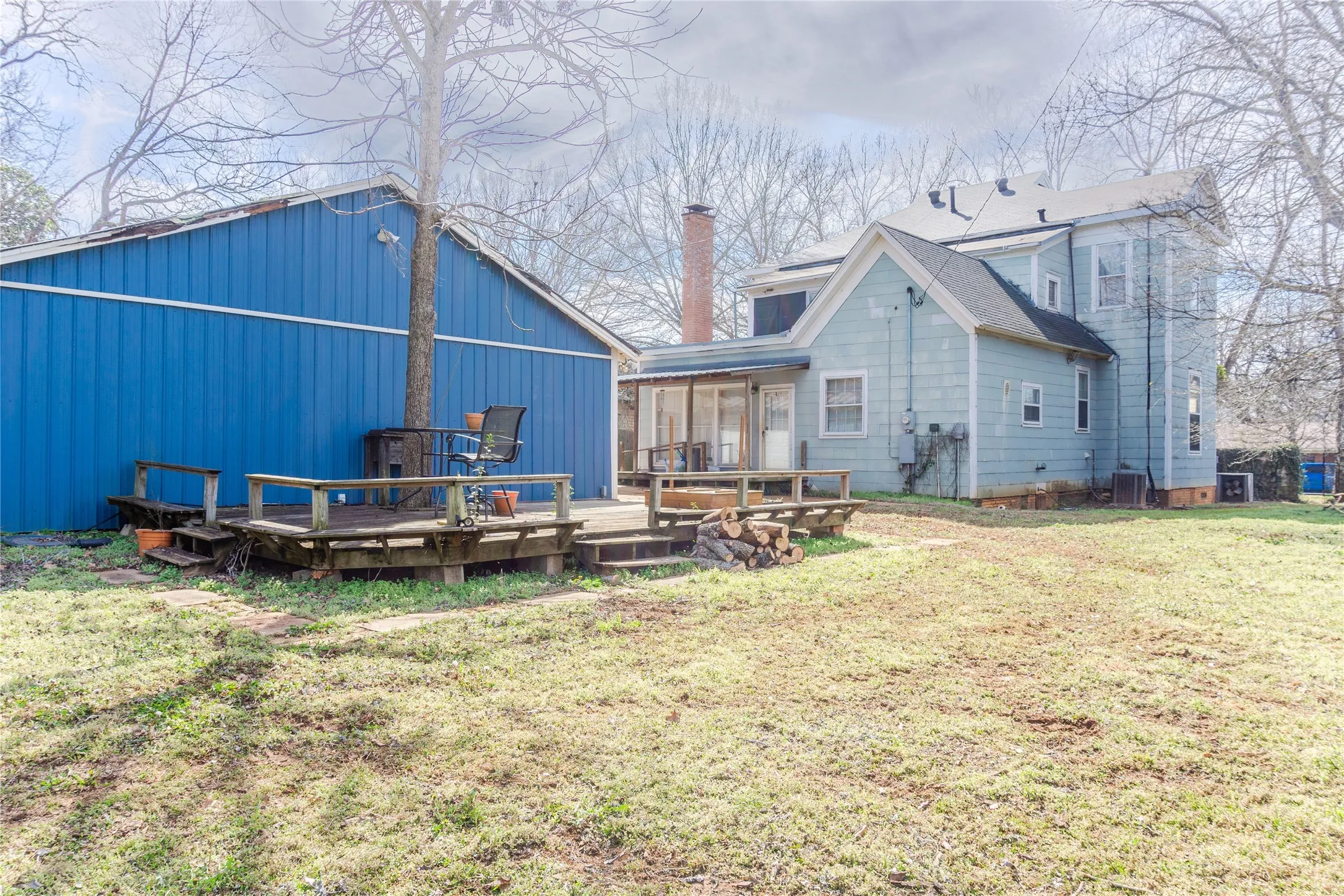 Rear view of house with a wooden deck and a lawn