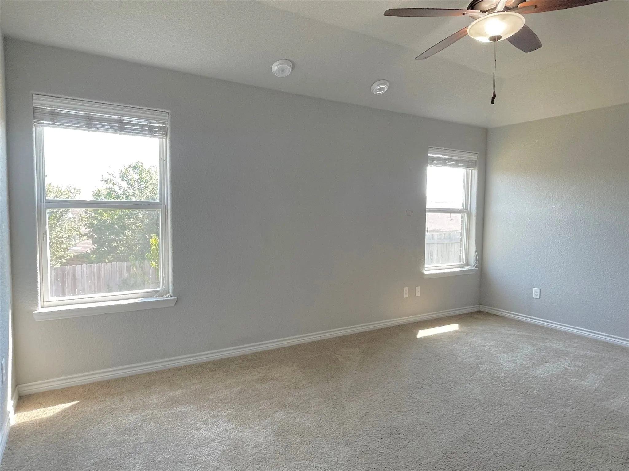 Isolated primary bedroom with a ceiling fan