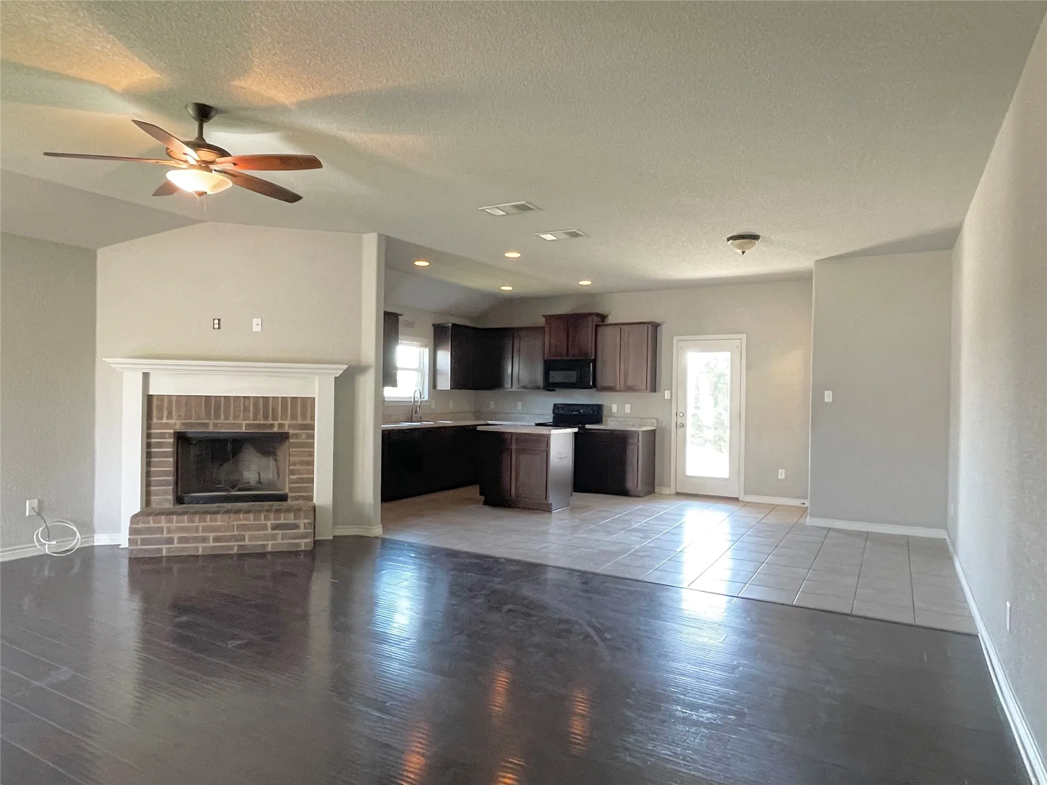 Kitchen with open floor plan, light countertops, plenty of natural light, and dark brown cabinets