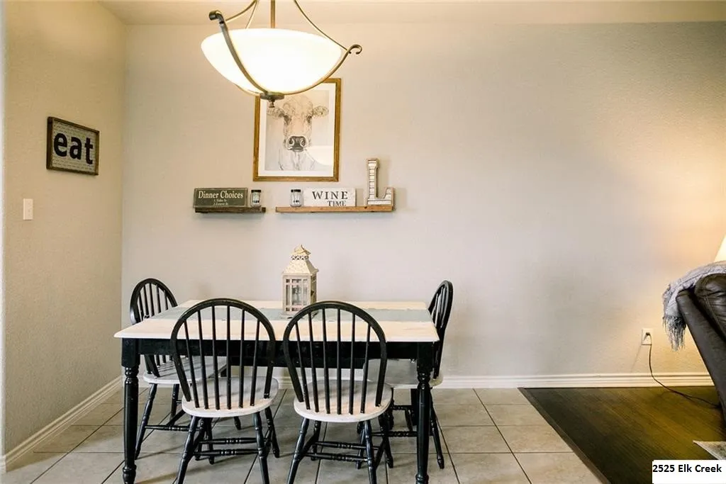 Dining room featuring light tile patterned floors and baseboards