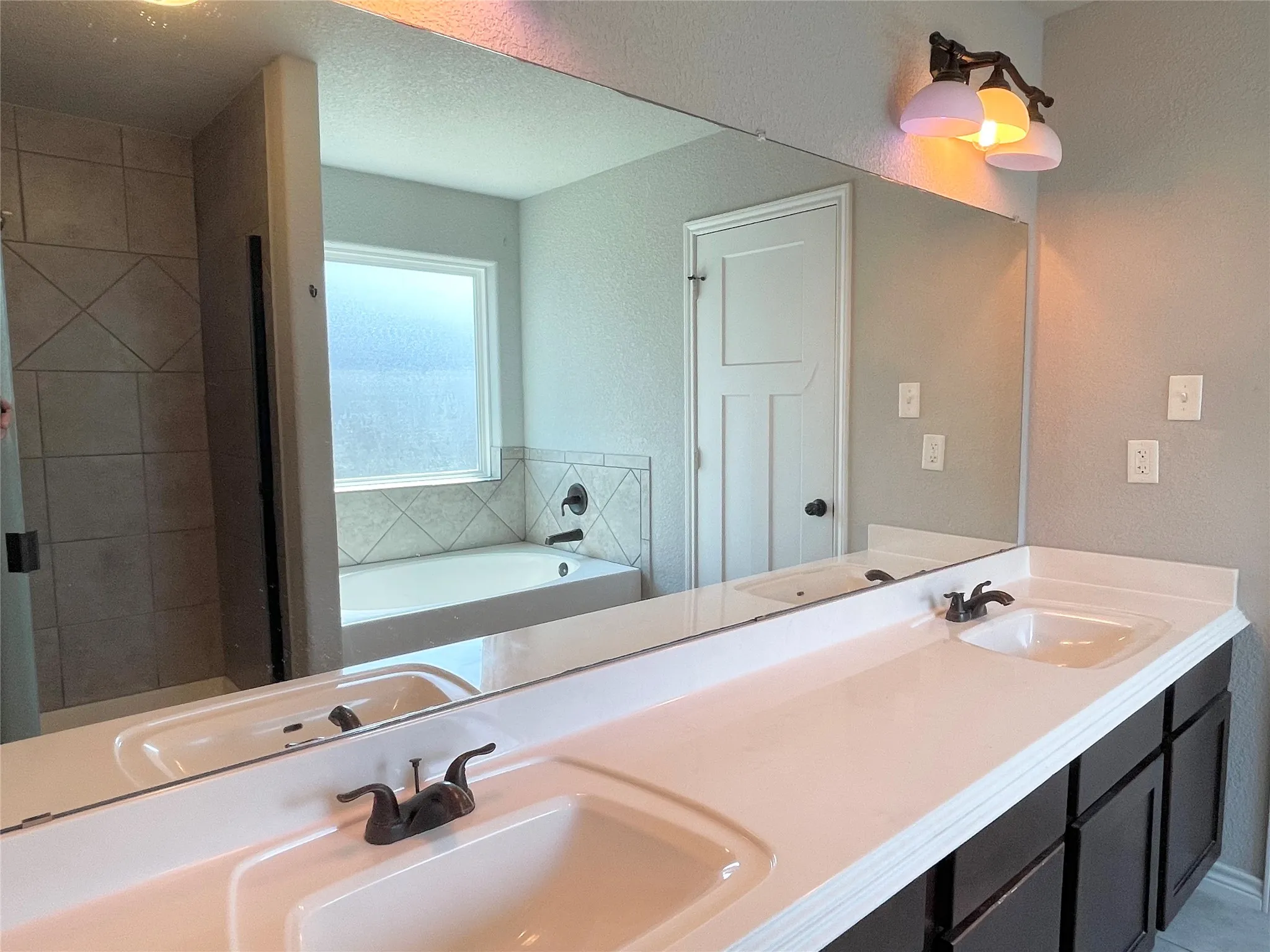 Full bath featuring a garden tub, double vanity, and stall shower