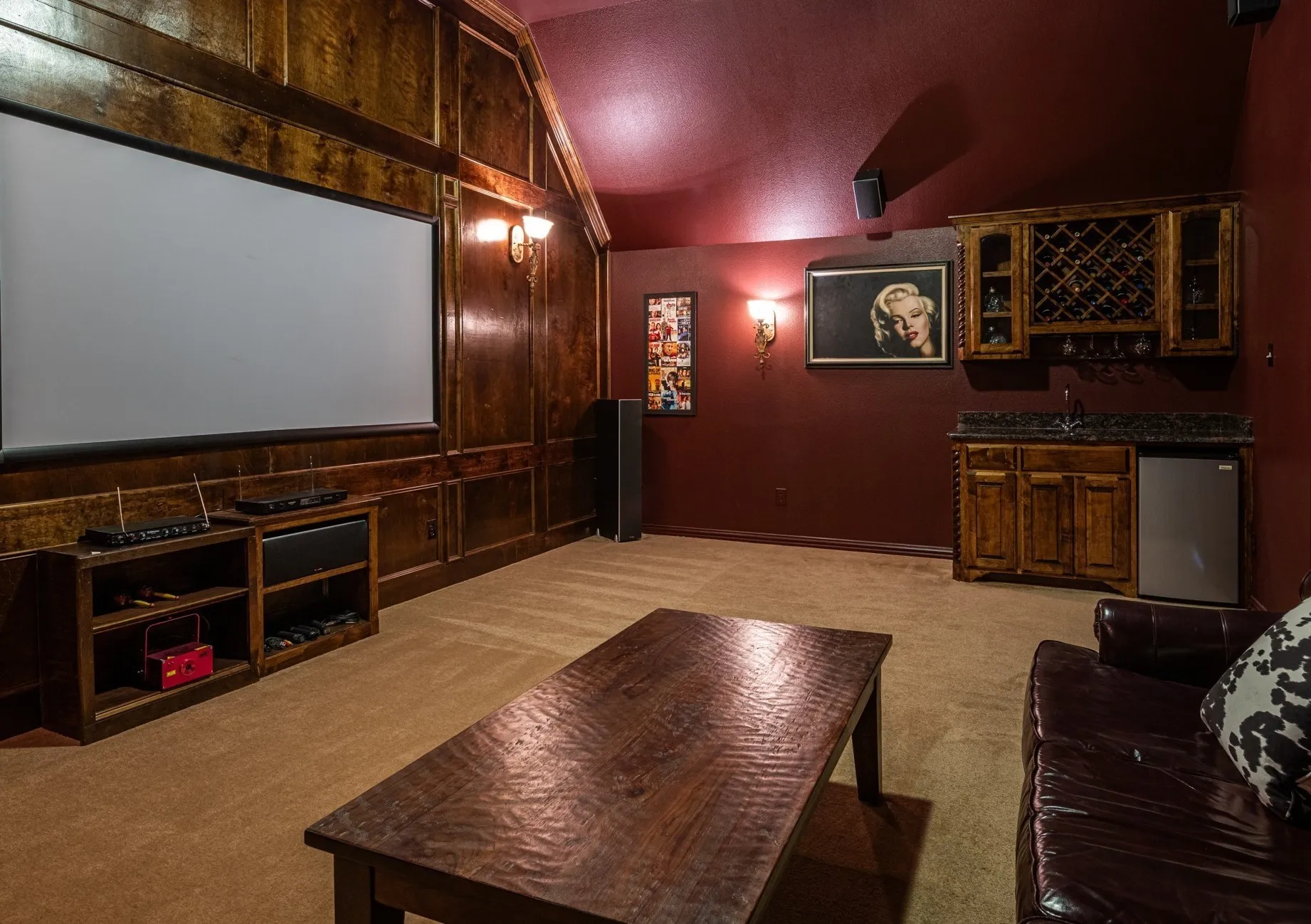 Cinema room featuring lofted ceiling and custom builti-in wet bar.  Ready for Movie nights and Game Days!