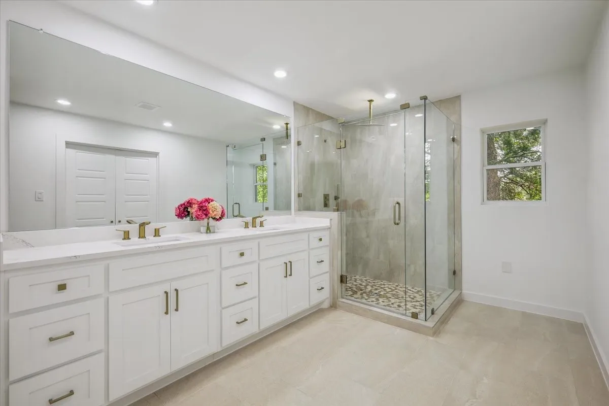 Full bathroom featuring double vanity, a shower stall, plenty of natural light, and recessed lighting