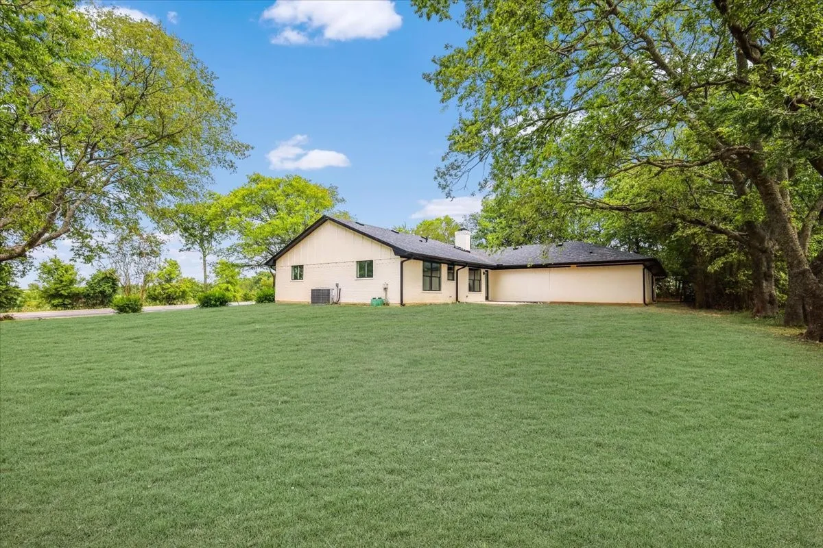 Back of property with a yard and a chimney