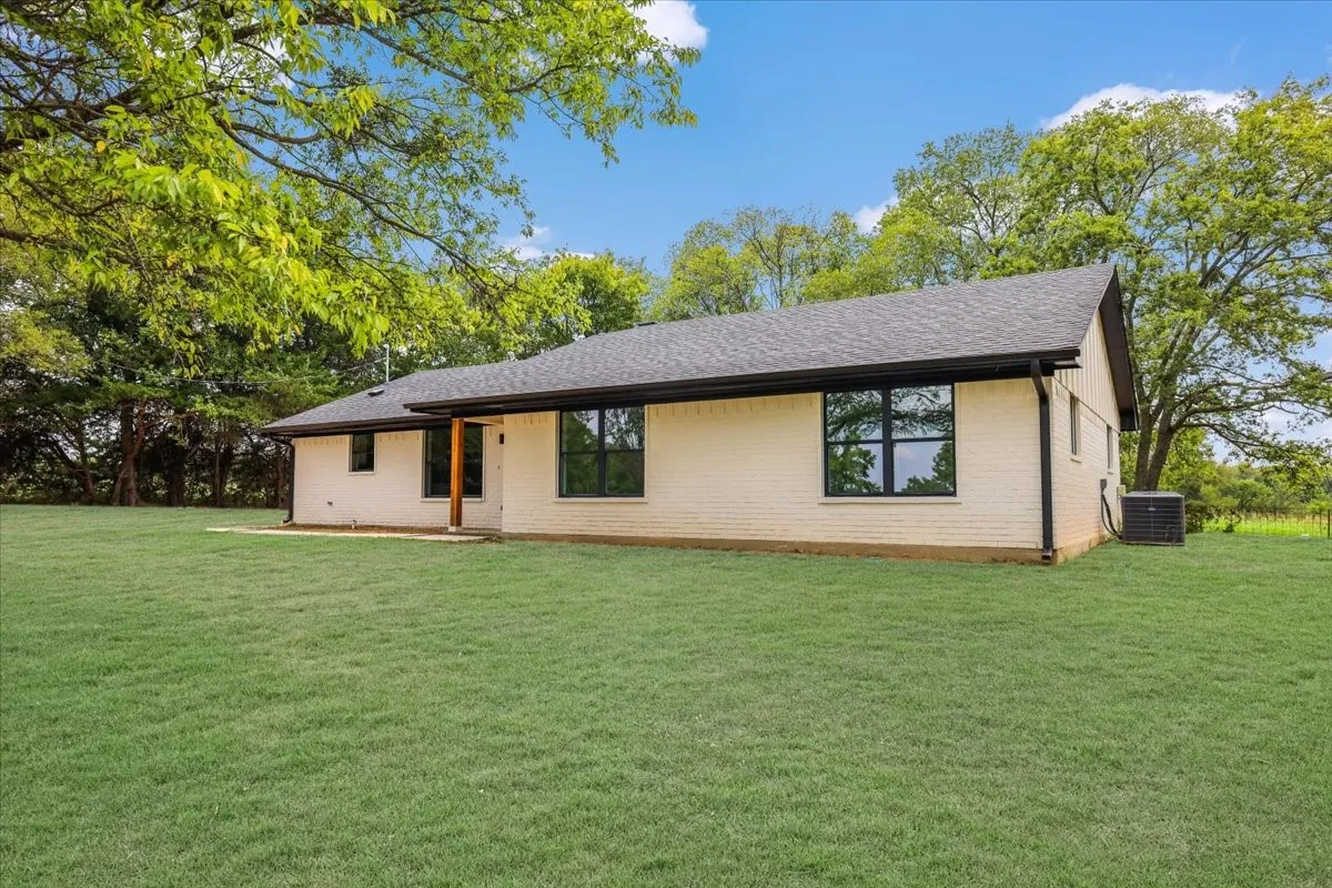 View of front of home featuring a front lawn, brick siding, and a shingled roof