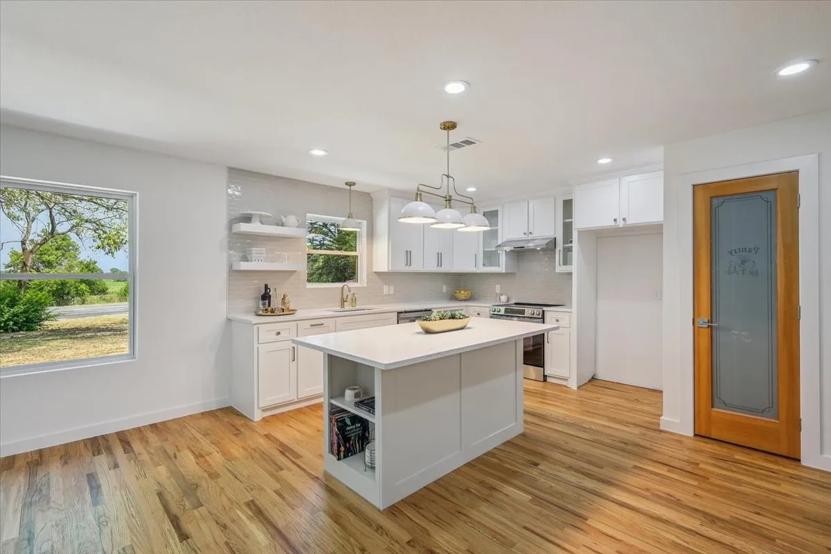 Kitchen with open shelves, white cabinetry, backsplash, and recessed lighting