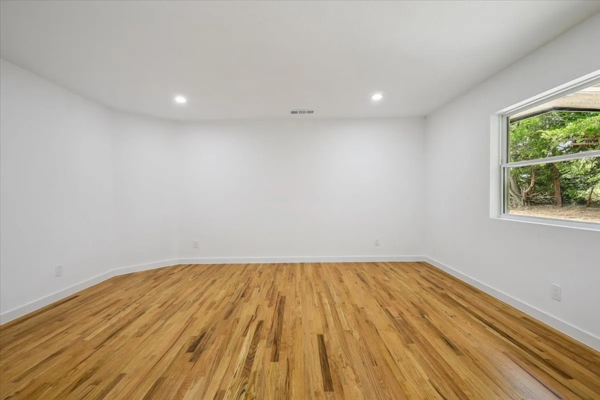 Empty room featuring light wood-style floors and recessed lighting