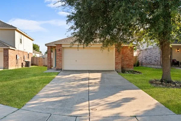 View of front of house featuring brick siding, a garage, and driveway
