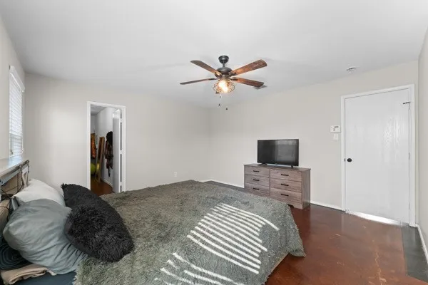 Bedroom with ceiling fan and finished concrete flooring