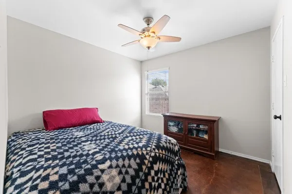 Bedroom with ceiling fan and concrete flooring