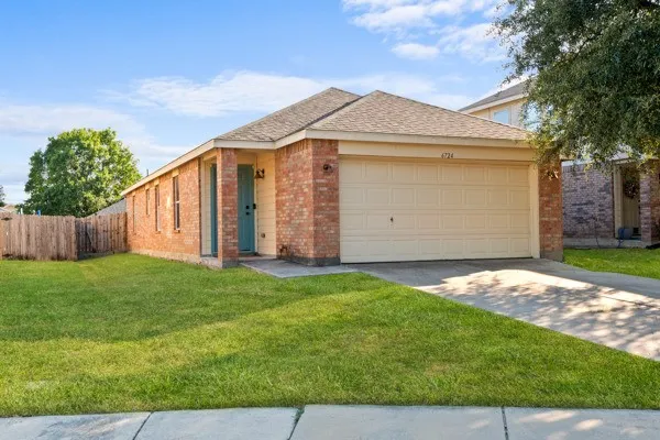 View of front of house featuring driveway, brick siding, roof with shingles, and an attached garage