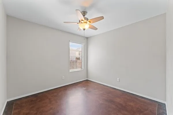 Spare room with a ceiling fan and concrete floors