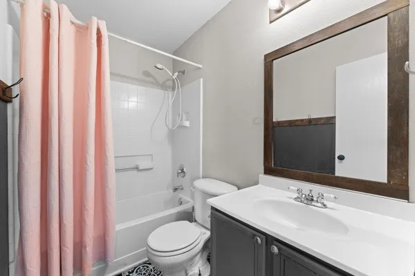 Full bathroom featuring shower / tub combo with curtain and vanity
