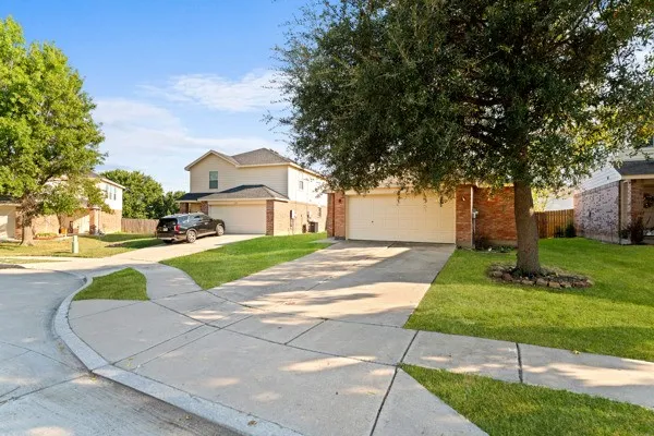 View of front facade with concrete driveway, brick siding, and a garage