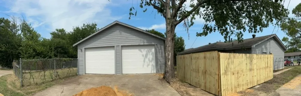 Detached garage with privacy fence in backyard