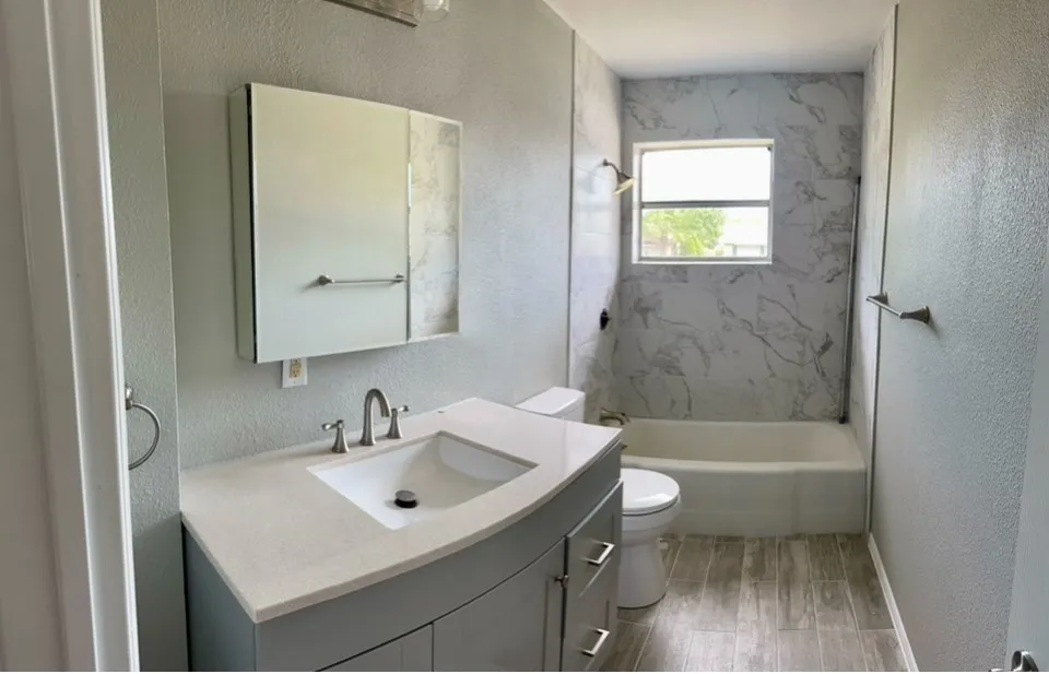 Full bathroom featuring toilet, vanity, hardwood / wood-style flooring, and tiled shower / bath large medicine cabinet