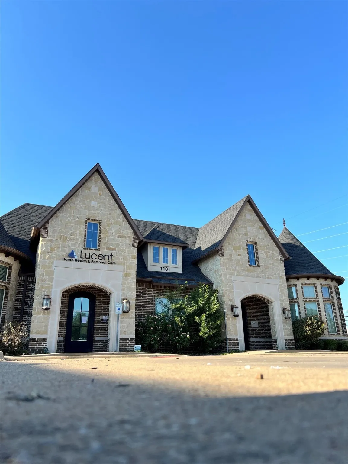 French provincial home with stone siding, a shingled roof, and brick siding