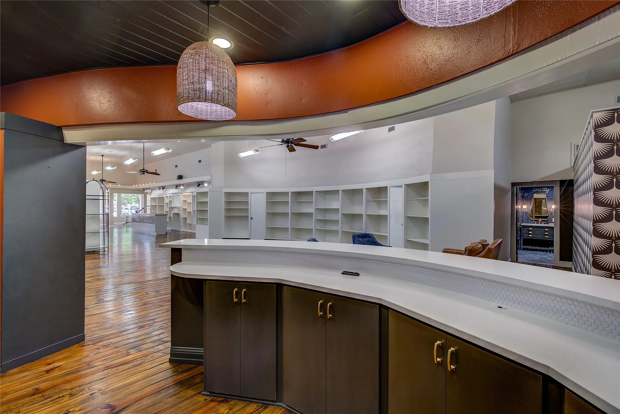Behind the bar is lots of built-in storage, wood ceiling, pendant lights, and recessed lighting.