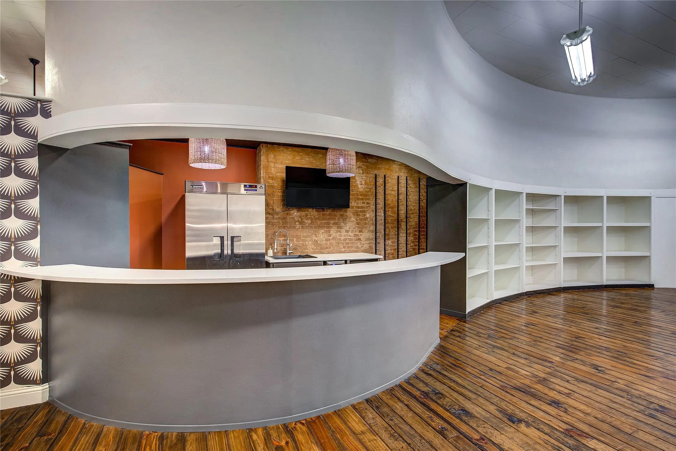 This gorgeous curved bar has marble counters and a serving area behind; note the original exposed brick!