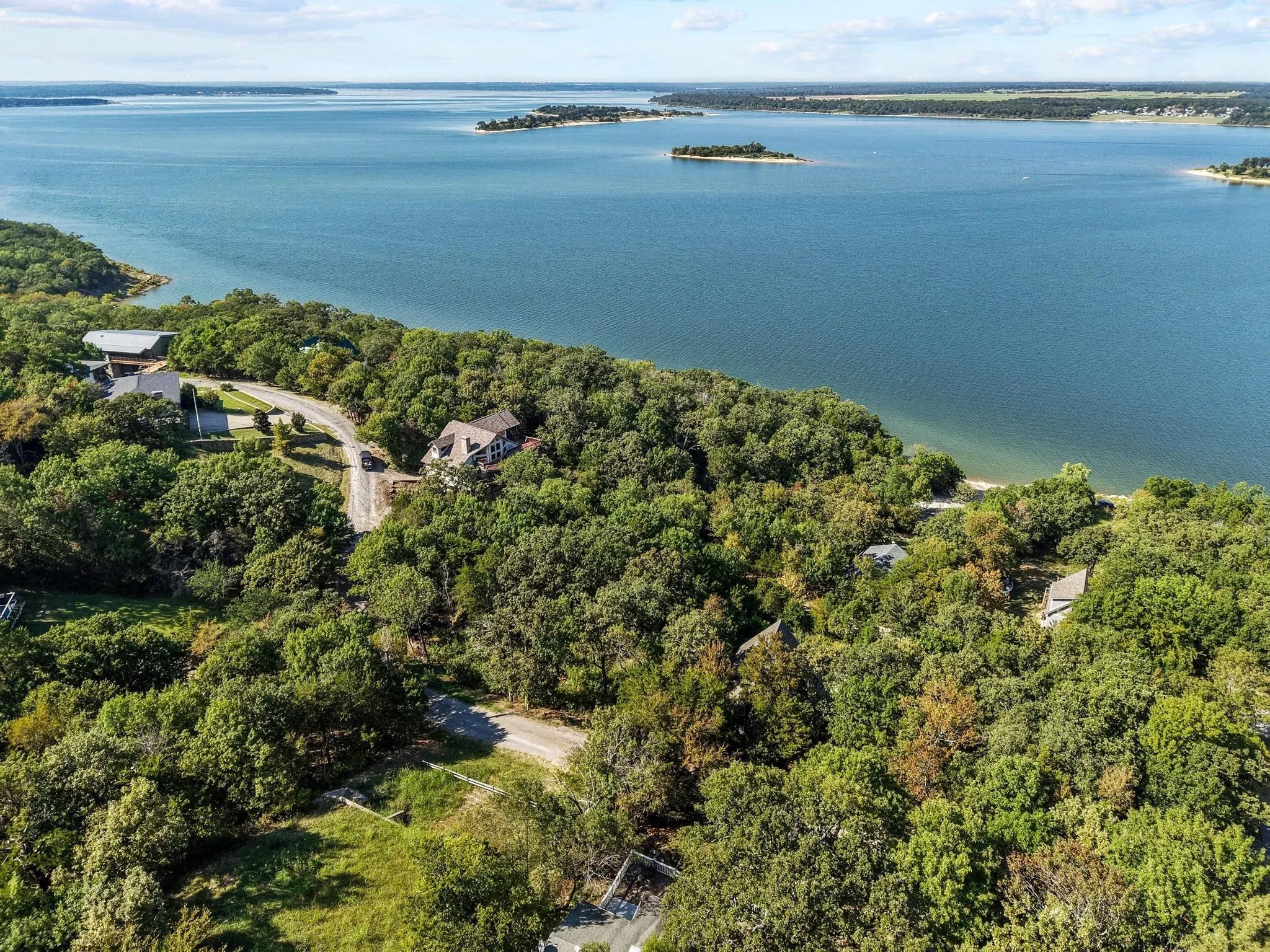 Aerial view of property's location featuring a large body of water and a heavily wooded area