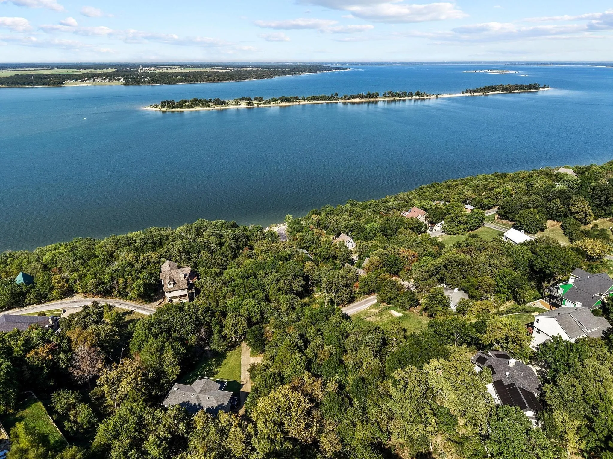 Aerial view of a nearby body of water and a heavily wooded area