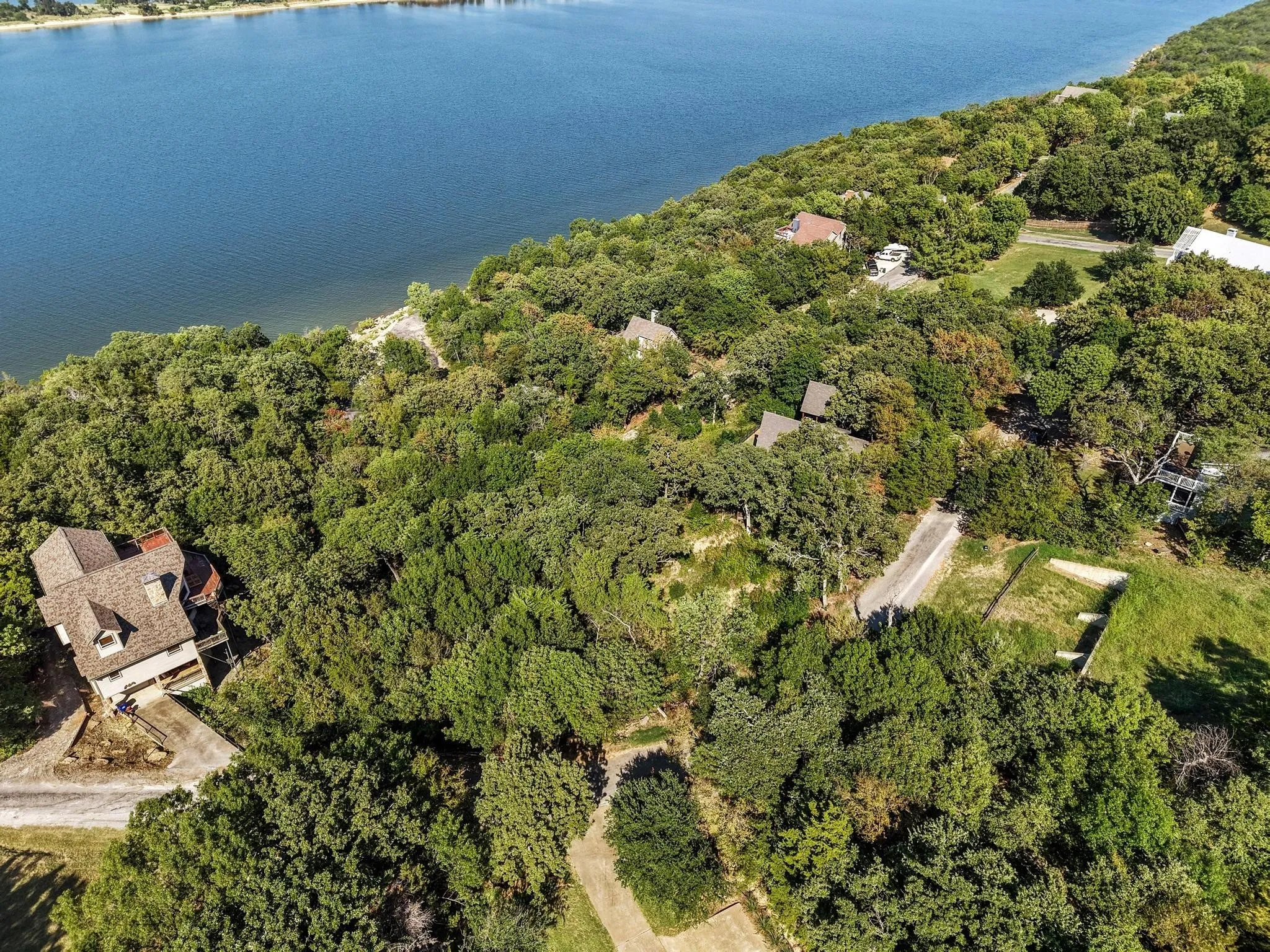 View of property location featuring a heavily wooded area and a nearby body of water