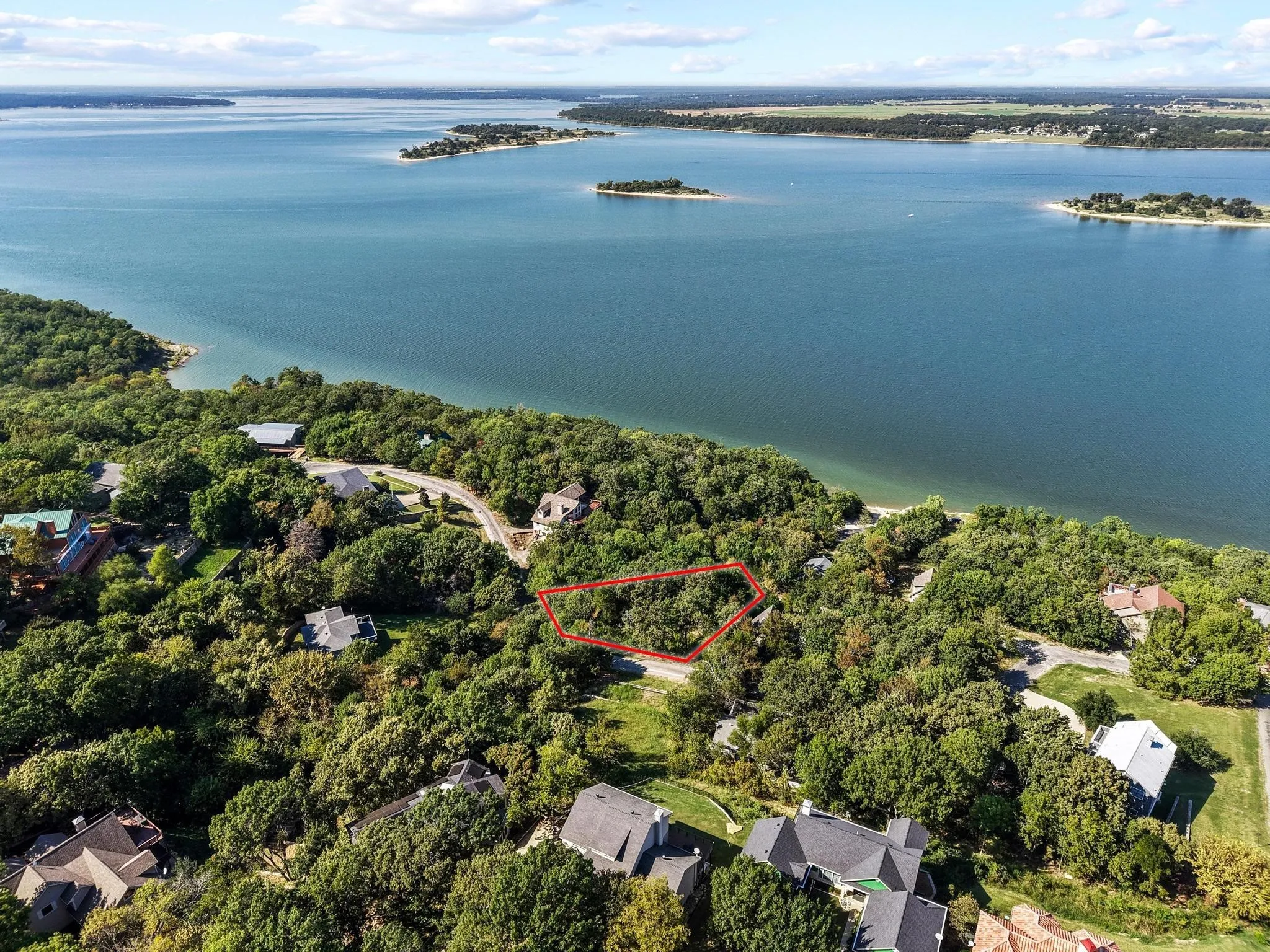 Aerial overview of property's location with property parcel outlined, a large body of water, and nearby suburban area
