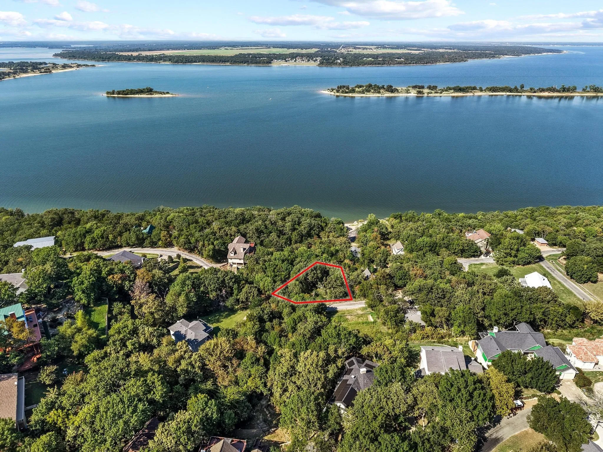 Aerial overview of property's location featuring property parcel outlined, a nearby body of water, and nearby suburban area