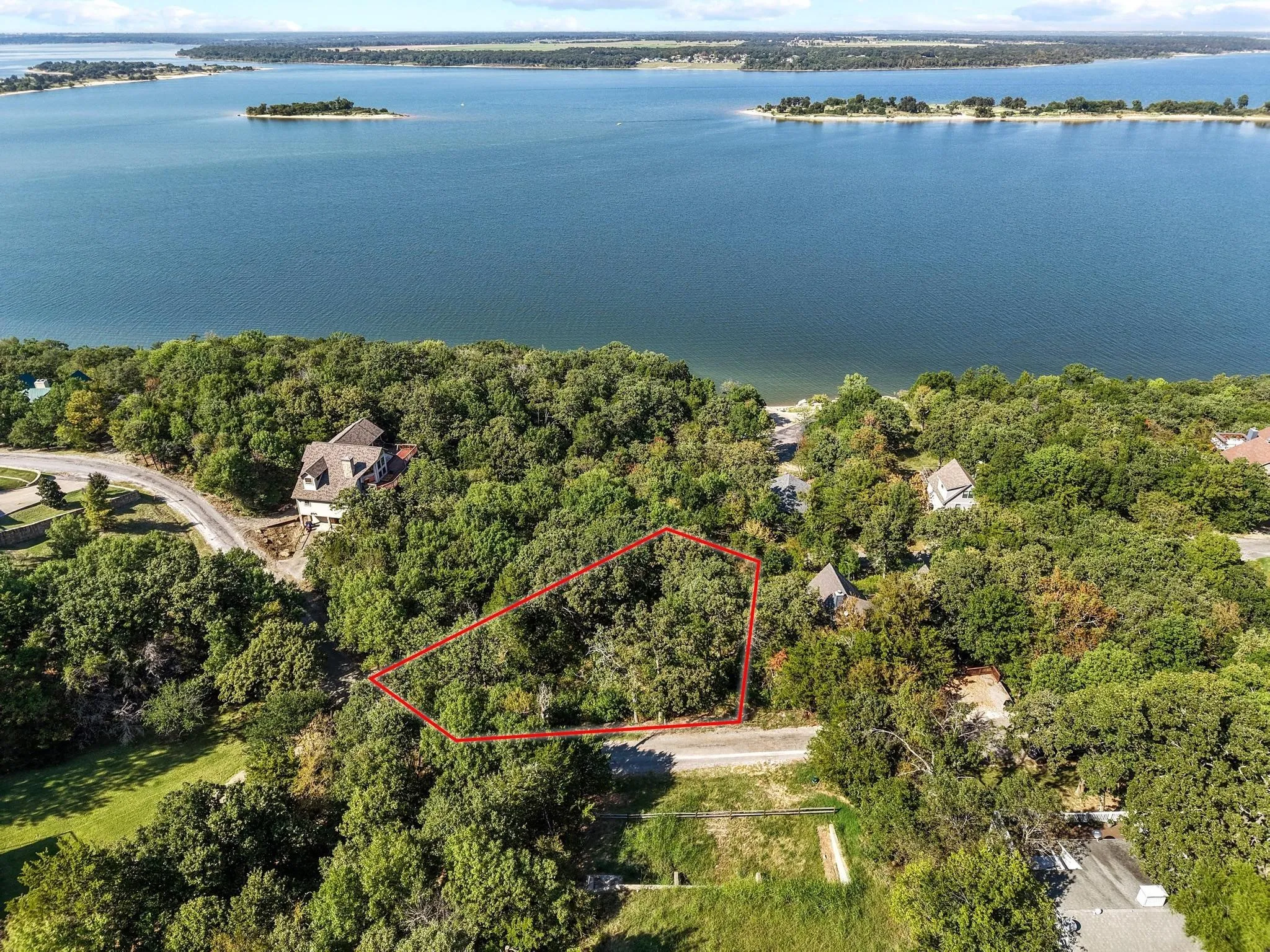 Aerial view of property and surrounding area featuring property boundaries highlighted and a large body of water